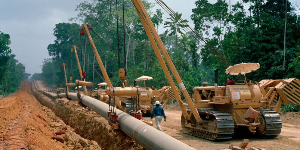KRIBI, CAMEROON - MARCH 2002: Welders join 40 foot sections of pipeline which will carry oil from the land-locked oil fields of Chad through the jungles of Cameroon to the Gulf of Guinea.  The 660 mile Exxon Mobil pipeline cost $3.5 billion and will carry 225,000 barrels of oil a day to a marine terminal for export. (Photo by Tom Stoddart/Getty Images)